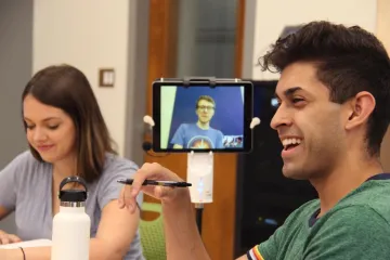 Students meeting around a table laughing